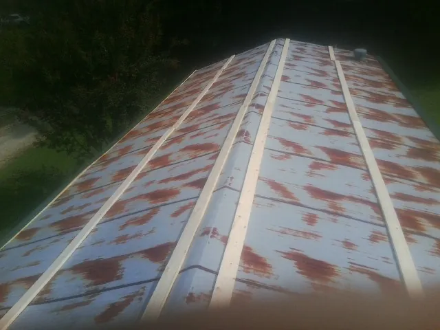 Rusted metal roof panels with new wood purlins before replacement — Storm Damage Roof Repair in Dennison by Roofing Brothers