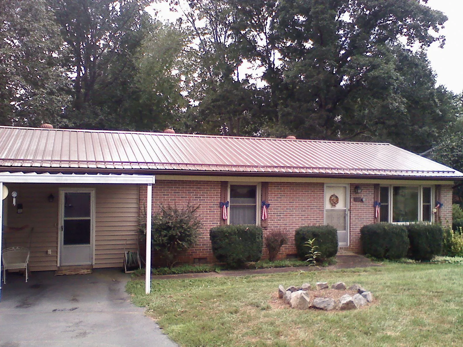 Bronze metal roof and carport on a brick ranch home — Roof Repair work by our crew in Dennison